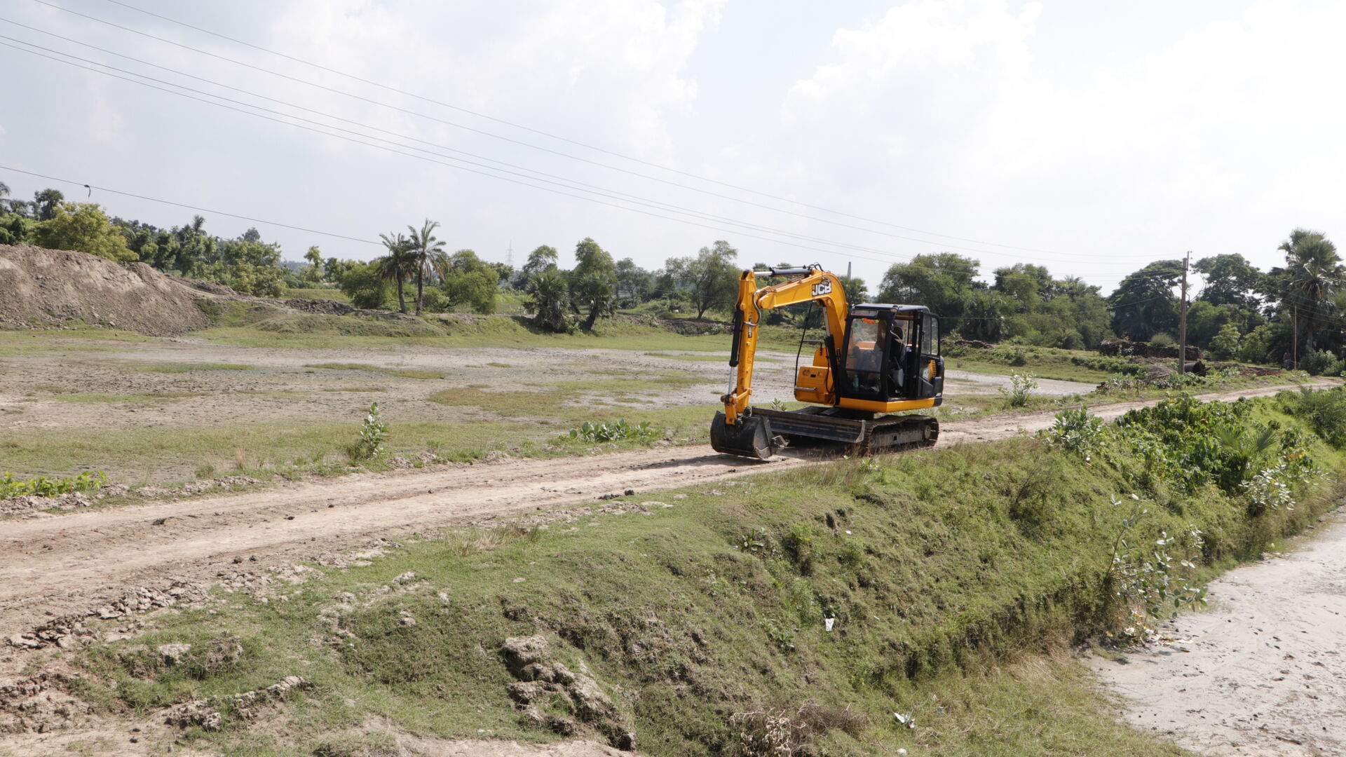 JCB JS81 tracked excavator tracking down a road. 